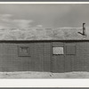 House in shantytown on Nueces Bay, Corpus Christi, Texas. Notice siding of old automobile license plates. House is occupied by migrant workers