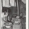 Mexican girl living in corral making tortillas. Tortillas can be seen baking on the stove. Robstown, Texas