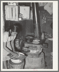 Mexican girl living in corral making tortillas. Tortillas can be seen baking on the stove. Robstown, Texas