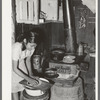 Mexican girl living in corral making tortillas. Tortillas can be seen baking on the stove. Robstown, Texas