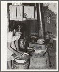 Mexican girl living in corral making tortillas. Tortillas can be seen baking on the stove. Robstown, Texas