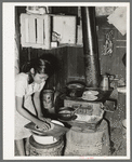 Mexican girl living in corral making tortillas. Tortillas can be seen baking on the stove. Robstown, Texas