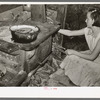 Daughter of white migrants reaching for stick of wood. Sebastian, Texas