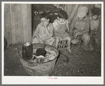 Mexican children sitting outside of corral before fire built in wash tub. Robstown, Texas