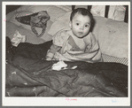 Mexican child in bed. The baby has impetigo. Crystal City, Texas