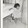 Mexican child in corner of room with dirt floor. Crystal City, Texas