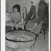 Mexican mother and child. Fires built in old galvanized tubs are used both for heat and cooking throughout the Mexican section. Crystal City, Texas