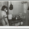 Mexican girl drinking a cup of water in the kitchen of her home in San Antonio, Texas