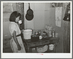 Mexican girl drinking a cup of water in the kitchen of her home in San Antonio, Texas