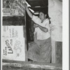 Mexican woman standing in doorway of kitchen. San Antonio, Texas. Notice the cardboard partitions