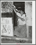 Mexican woman standing in doorway of kitchen. San Antonio, Texas. Notice the cardboard partitions