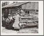 Mrs. Hale and her oldest son in front of their home near Black River Falls, Wisconsin. This farm house was built with a total expenditure of three dollars in money