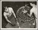 Packing filled cans into cooking basket. Canning factory, Sun Prairie, Wisconsin