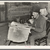 William Besson, iron ore prospector, examining geological survey maps in his cabin near Winton, Minnesota