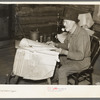 William Besson, iron ore prospector, examining geological survey maps in his cabin near Winton, Minnesota