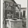 Mexican girl drawing water from well. City water is not supplied to all sections of the city. San Antonio, Texas