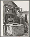 Mexican girl drawing water from well. City water is not supplied to all sections of the city. San Antonio, Texas