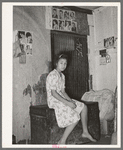 Mexican girl sitting in front of bedspring which formed partition between the family's living quarters and those of a man boarder. San Antonio, Texas, corral