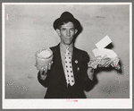 Mexican pecan workers union official displaying relief supplies which are supposed to feed a family of three for two weeks. The articles shown are beans and butter. San Antonio, Texas