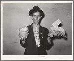 Mexican pecan workers union official displaying relief supplies which are supposed to feed a family of three for two weeks. The articles shown are beans and butter. San Antonio, Texas