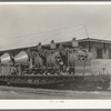 Concrete mixers on railroad flatcar. Eagle Pass, Texas