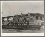 Concrete mixers on railroad flatcar. Eagle Pass, Texas