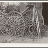 Wagon wheels and automobile exhaust pipes in front of blacksmith shop. San Antonio, Texas