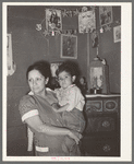 Mexican mother and child in front of shrine in corner of room. San Antonio, Texas