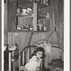 Mexican child in kitchen. San Antonio, Texas. Notice the basket swing suspended from the ceiling