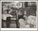 Mexican woman resting on bed in her home. San Antonio, Texas