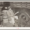 Mexican spinach peddler reading the newspaper about 4:30 in the morning. San Antonio, Texas
