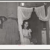 Mexican girl in doorway between living room and kitchen. San Antonio, Texas
