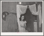 Mexican girl in doorway between living room and kitchen. San Antonio, Texas