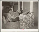 Tomato peddler asleep in back of his truck at early morning vegetable market. San Antonio, Texas