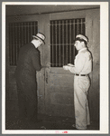 Unlocking the door of a commission house opposite the vegetable market. San Antonio, Texas