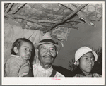 Mexican father, daughter and grandchild in shack home. San Antonio, Texas