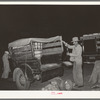 Setting up the scales on a vegetable truck at the early morning market. San Antonio, Texas