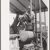 Pouring gasoline into combine engine, Walla Walla County, Washington