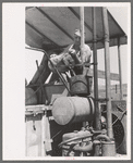 Pouring gasoline into combine engine, Walla Walla County, Washington