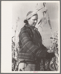 Farmer (widow) husking corn. She lives on Black Canyon Project and has a FSA (Farm Security Administration) loan, Canyon County, Idaho