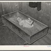 Baby of family living on relief. Notice the homemade cradle. Near Jefferson, Texas. Housing conditions in this section are particularly bad