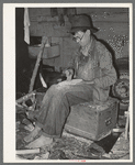 Migrant worker who makes ornaments from horns. He is filing down a wooden block to be used as base for horns. Near Hammond, Louisiana
