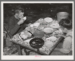 White migrant berry picker and son eating dinner near Hammond, Louisiana