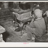 Negro boy sitting by the stove on a cold day in the strawberry picking season. Near Independence, Louisiana