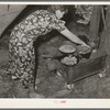 White migratory berry picker preparing dinner in front of tent near Hammond, Louisiana