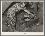 White migratory berry picker preparing dinner in front of tent near Hammond, Louisiana