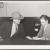 Sheriff of adjoining county talking to cashier in bank. San Augustine, Texas