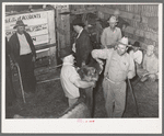 Looking at cow's teeth in auction barn. San Augustine, Texas
