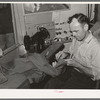 Tailor shortening a pair of trousers. San Augustine, Texas