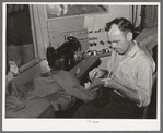 Tailor shortening a pair of trousers. San Augustine, Texas